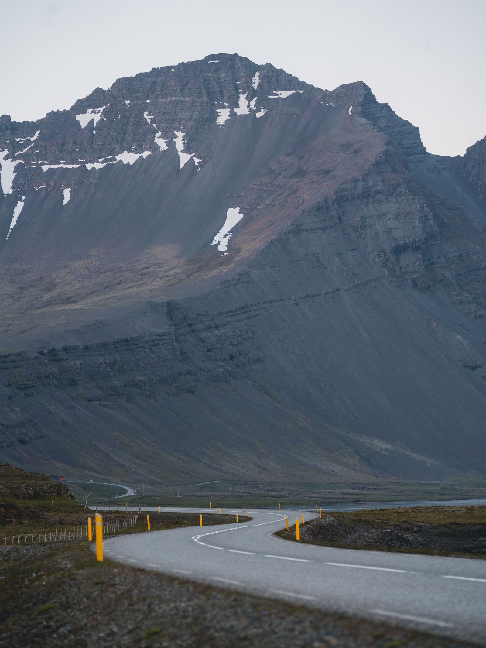 Iceland's Ring Road cutting through a dramatic volcanic landscape under a moody sky