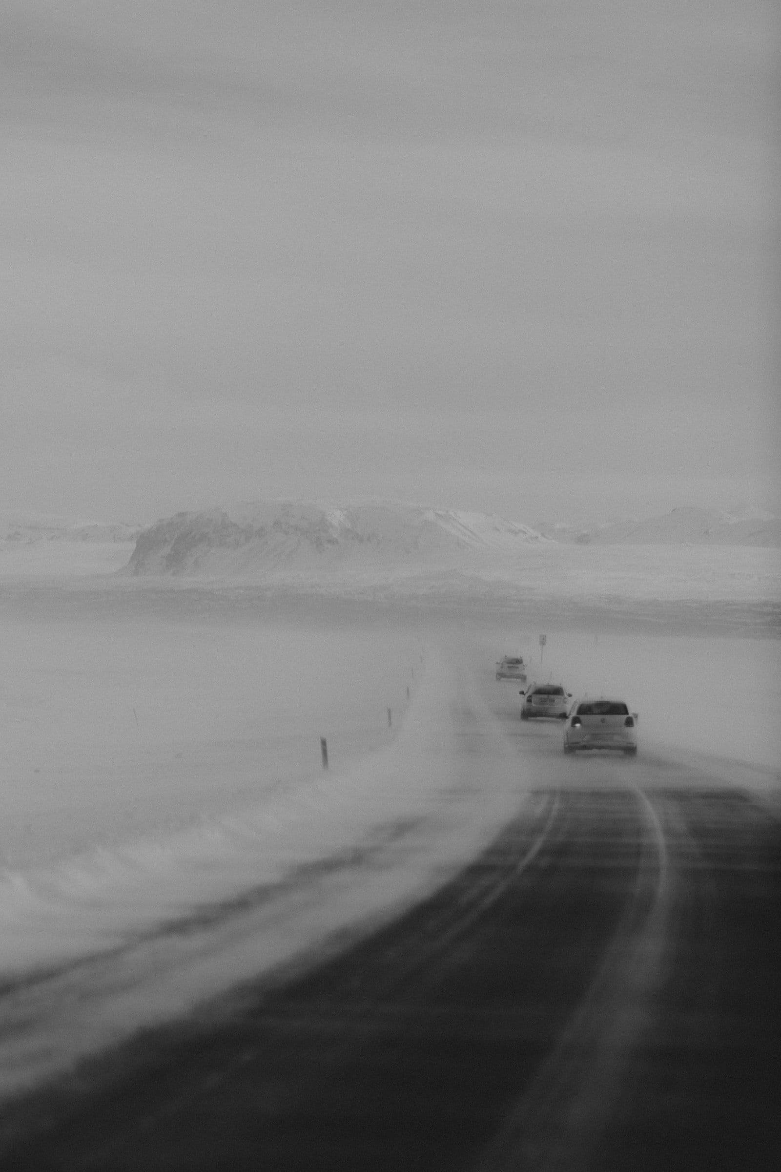 Rental cars parked in a snowy Icelandic car park in winter — all vehicles fitted with studded winter tyres